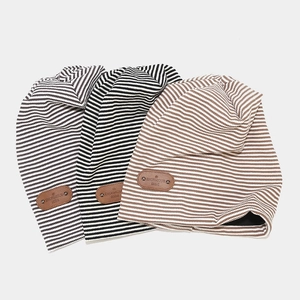 Retro plaid knitted beanie hat with leather patch in black, grey, and brown stripes