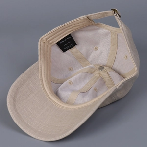 Detail of linen baseball cap interior showing metal buckle and 100% cotton inner lining
