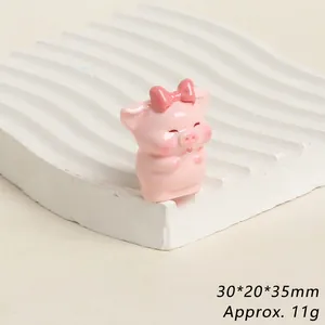 Detailed view of pink resin pig figurine with bow, size 30x20x35mm, weight approx 11g