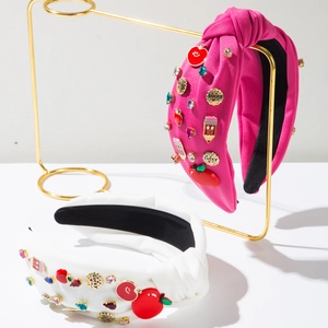Detail of knot headbands with colorful apple and pencil charms with rhinestone accents
