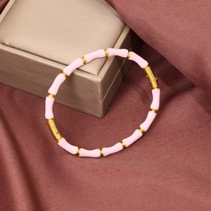 Pink enamel bamboo-style gold bangle with hidden clasp on silk background
