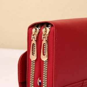 Detailed macro view of red leather wallet featuring double gold zippers and precise stitching