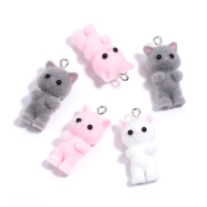 Detail of pink, grey, and white flocked cat charms with metal rings for DIY accessories
