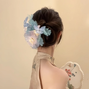 Mesh floral hair clip with pearls and tassels shown on an elegant bun hairstyle