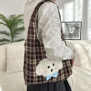 Detail of cute plush puppy patch on brown plaid tote bag with light blue bow accent