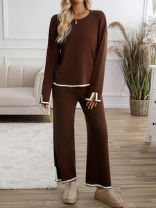 Detail of knit long-sleeve sweater set featuring contrasting white trim on cuffs and hemline