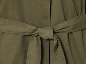 Détail de la ceinture nouée d'un trench-coat vert armée avec texture de tissu