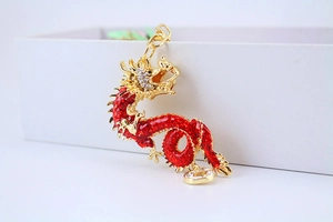 Close-up of golden Chinese dragon keychain with red enamel and sparkling rhinestones