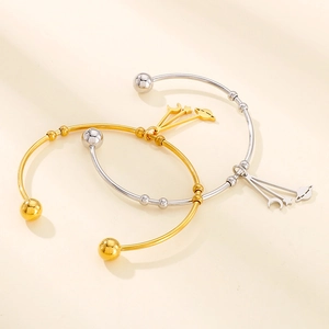 Detail view of celestial open bangles with moon and planet charms in gold and silver