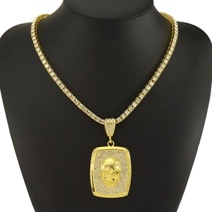 Détail d'une chaîne tennis hip-hop dorée avec pendentif crâne sur buste noir