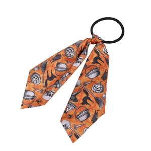 Detail of Halloween hair scrunchie with vintage orange bow featuring pumpkin and skull patterns