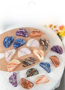 Detailed arrangement of large acrylic claw clips with marble texture on a palette