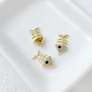 Detailed view of 14k gold-plated fish bone pendants with sparkling zircon stones