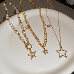 Detail of multi-layered gold star and pearl necklace set with OT clasp and star pendants