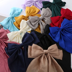 Close-up of various colorful satin hair bows with elegant long ribbons and silky texture