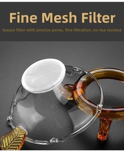 Detailed macro view of glass tea strainer with amber leaf handle and fine mesh filter