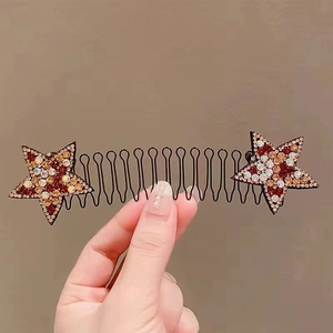 Detail of star-shaped hair comb with colorful rhinestones on a wavy black metal base