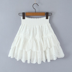 Détail d'une mini-jupe blanche en dentelle avec volants superposés et taille élastique