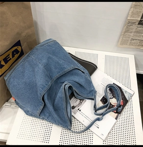 Macro view of washed denim tote bag showing detailed stitching and soft fabric texture