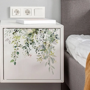 Floral self-adhesive wall decal with watercolor green leaves on a white bedside cabinet