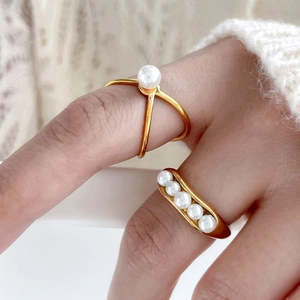 Close-up of gold-plated pea rings with freshwater pearls on a delicate knit background
