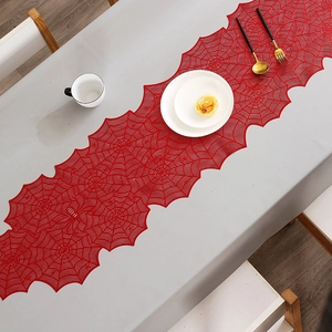 Detail of red spiderweb lace table runner showing intricate hollow mesh texture and pattern