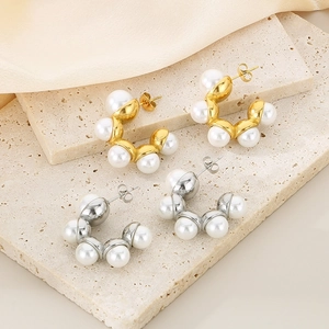 Détail de boucles d'oreilles perles en C dorées et argentées sur pierre et soie