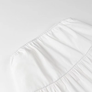 Detailed macro view of white elasticated ruched fabric on a minimalist strapless crop top