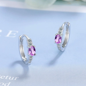 Detail showing elegant purple oval zircon earrings with silver hoop and micro-set crystals
