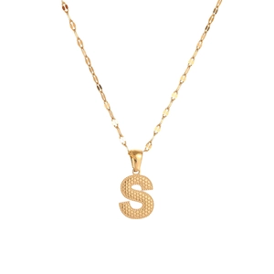 Macro shot of gold-plated letter S pendant with textured metal surface detail