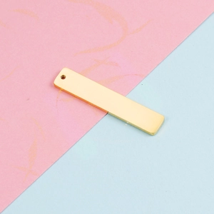 Macro detail of golden mirror polished stainless steel rectangle pendant for DIY jewelry
