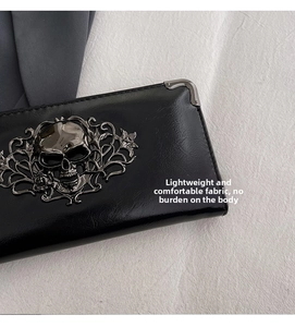 Macro view of black leather wallet featuring metallic skull relief and corner reinforcement