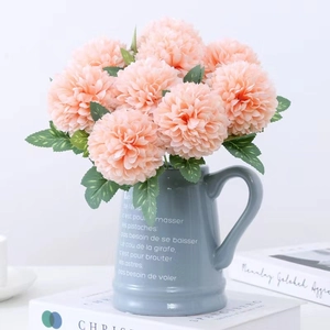 Pink faux dandelion pompom chrysanthemum flowers in a grey ceramic vase for home decor