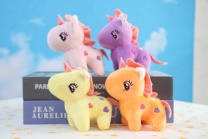 Close-up of four colorful plush unicorns with heart embroidery on a floral background