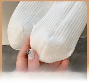 Close-up of white ribbed socks featuring reinforced toe for durability and elastic comfort
