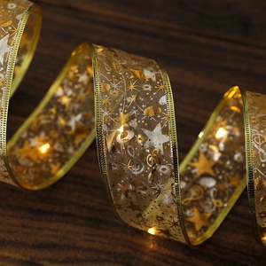 Detail of golden LED ribbon with warm glowing lights and star patterns on wood