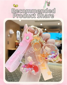 Detail of glitter liquid keychains with mini bear charms and star sequins in hand