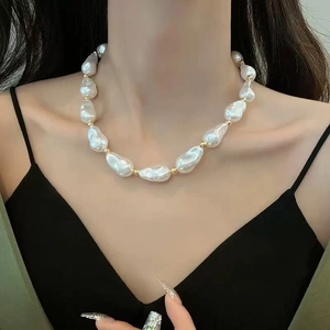 Close-up of Baroque irregular pearl necklace with gold spacer beads on a model's neck