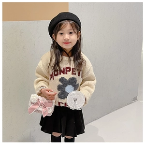 Detail of girls' cream knit sweater with red MONPETI text and dark floral embroidery
