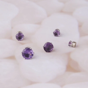 Macro detail of five purple zircon magnetic earrings with silver-tone metal settings