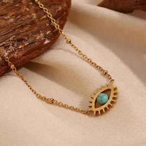 18K gold plated stainless steel necklace with turquoise evil eye pendant on wood