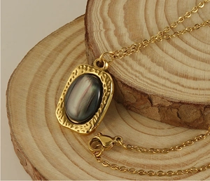 Detail of square tiger eye stone pendant on natural wood background with golden chain