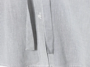 Close-up of the fine vertical stripes and button detail on a casual women top