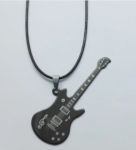 Detail of black guitar pendant with musical notes on a braided leather cord necklace