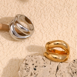 Detailed view of irregular twisted gold and silver minimalist rings on a stone base