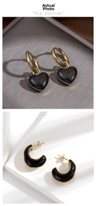 Detailed view of black heart drop earrings and C-shaped hoops with gold plating