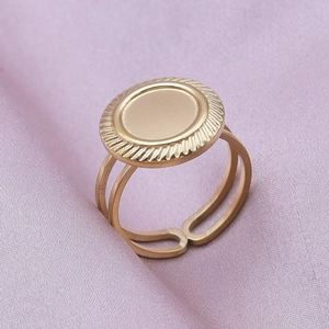 Macro shot of gold stainless steel oval signet ring with rope edge on purple satin background