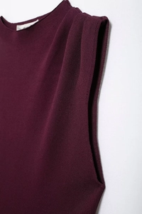 Primer plano de vestido de punto burdeos mostrando detalles del hombro y textura de la tela