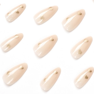 Minimalist nude almond press-on nails with elegant gold heart patterns on a white background