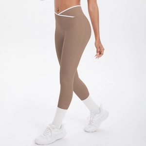 Détail du legging taille haute à coupe en V croisée et bordure contrastée blanche marron